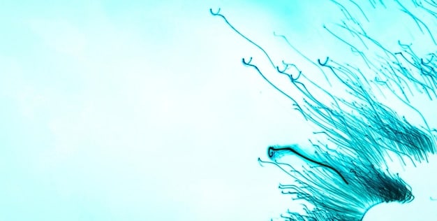 A photomicrograph showing healthy sperm cells swimming actively. The background is a light blue color, highlighting the sperm.