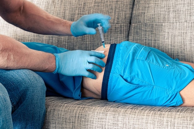 A doctor holding a syringe about to inject Xiaflex into a patient's penis to treat Peyronie's disease. The image shows a close-up of the injection site and the doctor's gloved hands.