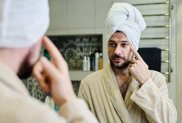 A man in his early 30s applying a serum to his face in a well-lit bathroom, with a focus on the product and his skin.