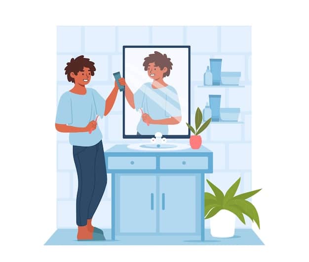 A man is standing in front of a mirror, carefully applying hair styling product to his hair. The background is a well-lit, modern-style bedroom with minimalist decor.