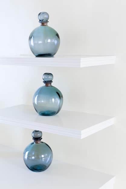 A close-up of a collection of cologne bottles organized on a shelf, with an emphasis on the variety of bottle designs and the ambient lighting that highlights the different colors of the liquid fragrances.