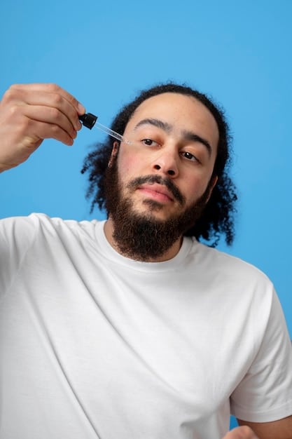 A close-up photo of a man applying face serum to his clean shaven face.