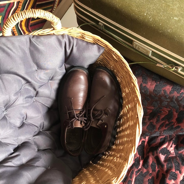 A pair of stylish brown leather loafers with a tassel detail, placed on a patterned rug in a well-lit room, showcasing their elegant yet relaxed appearance.