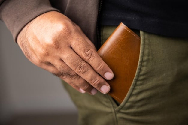 A close-up shot of a man's hands holding a well-worn, brown leather bifold wallet. The leather shows signs of wear and has a rich, textured patina. The background is blurred, with a focus on the wallet's details and craftsmanship.