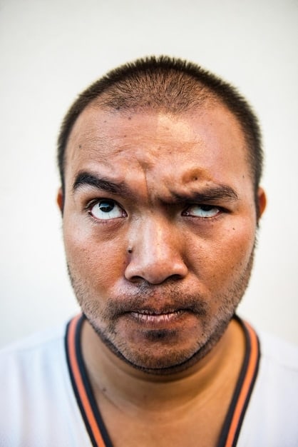 A close-up of a man's face, showing visible signs of fatigue, such as dark circles under his eyes, a furrowed brow, and a weary expression.