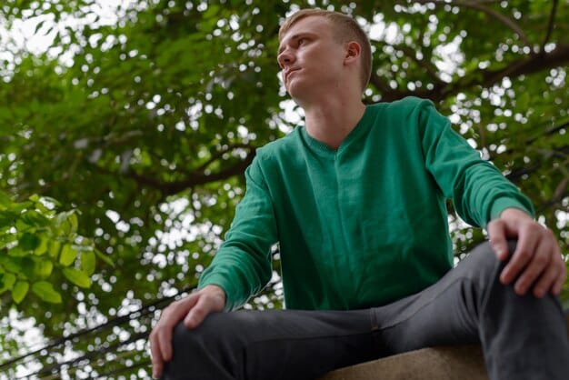 A man practicing deep breathing exercises in a park, with a serene expression on his face. The image is soft and calming, with natural lighting.