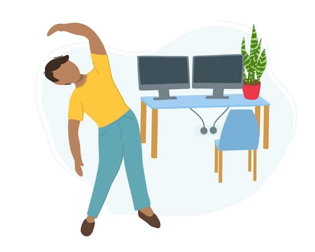 A person standing next to their desk, stretching their arms overhead with a slight side bend, representing a quick desk break.