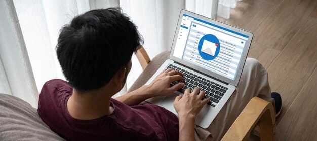 A person actively typing on a laptop, with a LinkedIn feed on the screen, showing various posts and comments, underscoring the importance of engagement and content creation.
