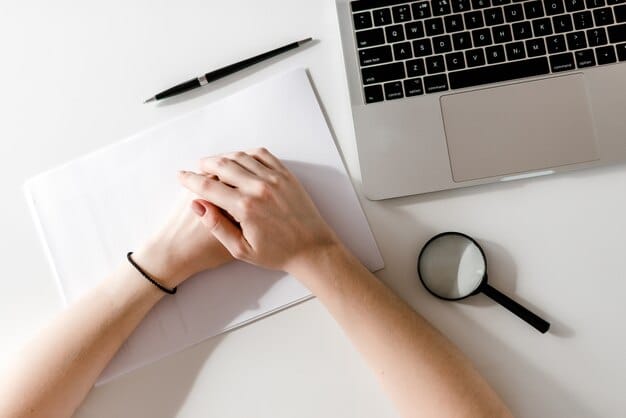 A person's hands meticulously editing a resume on a laptop, with a checklist and magnifying glass nearby, symbolizing attention to detail and optimization.