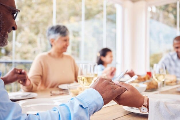Two diverse hands, one older and one younger, shaking firmly across a table with blurred business documents in the background, symbolizing a strong, evolving professional relationship and successful collaboration.