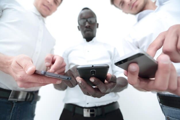 A close-up shot of a diverse group of hands, some holding smartphones, others holding business cards, with a blurred background of a modern office space. This represents the blend of digital and traditional networking methods.