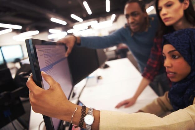 A diverse group of professionals engaged in a collaborative online learning session, with screens displaying charts, code, and creative designs, embodying modern skill acquisition.