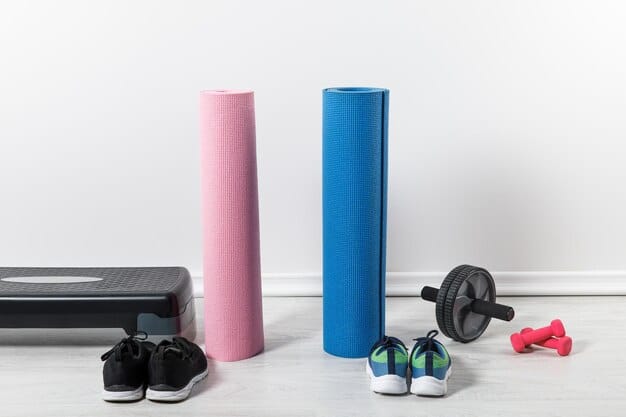 A tidy home gym setup featuring a pair of adjustable dumbbells on a compact rack, resistance bands hanging neatly, and a foam roller nearby on a light wooden floor.