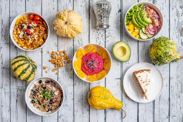 A vibrant, plant-based meal prep spread featuring colorful vegan power bowls, gluten-free wraps, and various nut milks, highlighting diverse options for different dietary needs.