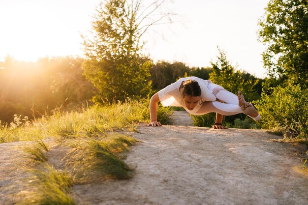 A man in athletic wear, mid-20s, performing a yoga pose outdoors at sunrise, symbolizing physical and mental balance and proactive health.