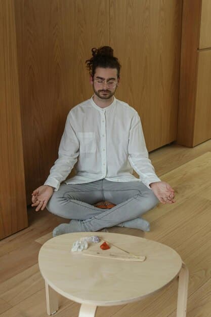 A man deeply focused, practicing meditation to regulate emotions in a calm indoor setting.