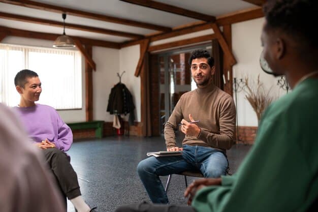 A group of men sitting in a circle during a support group session, actively listening and engaging with each other, showing comfort and mutual understanding in a supportive setting.