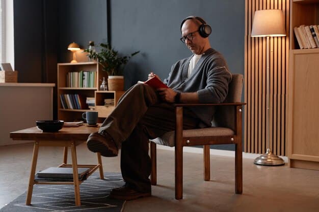 A man sitting calmly, with headphones on, perhaps listening to a guided meditation, in a modern, uncluttered home environment, suggesting a moment of peace and self-care.