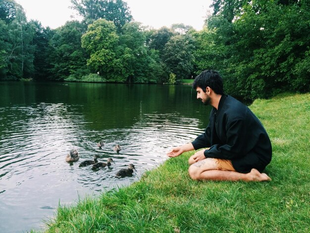 A man practicing meditation outdoors, possibly in a peaceful park or mountainous setting, signifying inner peace and mindfulness.