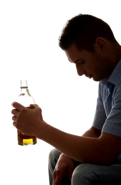 A man sitting alone, looking overwhelmed, with a subtle glow around his head suggesting mental health struggles, and blurred bottles in the background symbolizing substance abuse.