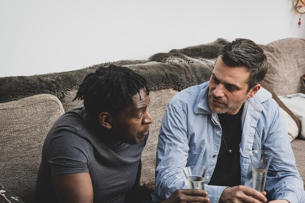 Two men in a support group setting, one speaking and the other listening attentively, symbolizing healthy communication and shared recovery journeys.