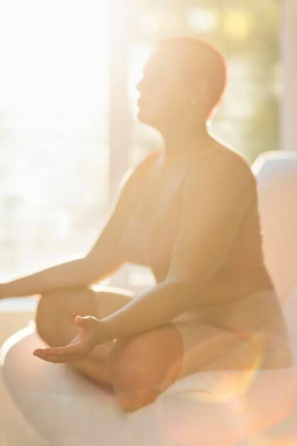 A serene image of a person meditating or practicing deep breathing, symbolizing mental calm and stress reduction. Soft focus, natural lighting.