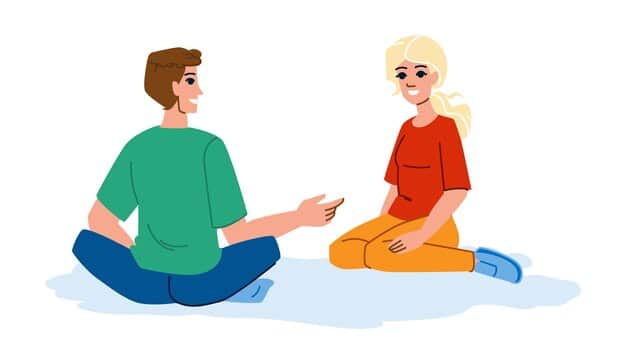 Two people sitting close, engaged in deep conversation, with one partner gently holding the other's hand, illustrating empathy and active listening.