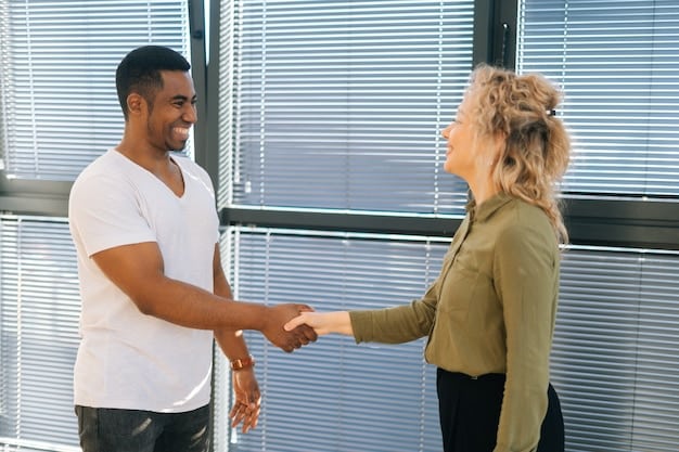 Two colleagues shaking hands after a meeting, with smiles and open body language, signifying resolution and agreement. The background is a bright, modern office setting. This image symbolizes successful conflict resolution and the importance of maintaining positive professional relationships, key to How to Handle Workplace Conflict: Resolve Issues Professionally and Maintain Positive Relationships.
