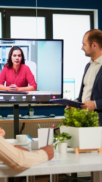 An executive is presenting a webinar from a home office setup. The screen behind them shows a LinkedIn profile page with a well-written article. The scene illustrates the executive sharing thought leadership content via LinkedIn, enhancing their professional brand.