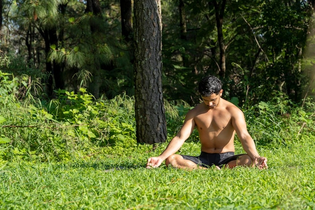 A man practicing yoga outdoors in a serene natural setting, with lush greenery and sunlight. The image conveys stress reduction, mindfulness, and a connection to nature, relevant to Boost Testosterone Naturally: The Updated 2025 Guide to Diet and Exercise.