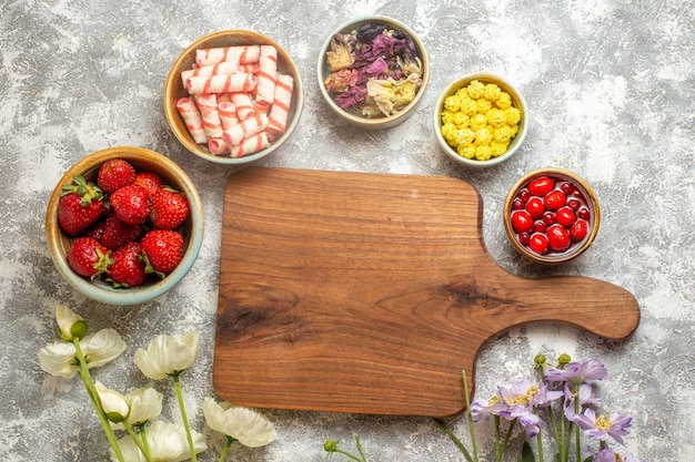 A top-down view of a wooden cutting board featuring a variety of fat-burning foods. Display lean proteins (chicken breast, fish), complex carbohydrates (brown rice, quinoa, sweet potato), healthy fats (avocado, nuts, olive oil), and plenty of colorful vegetables (broccoli, spinach, bell peppers). The arrangement should be visually appealing and highlight the diversity of foods that support fat loss.