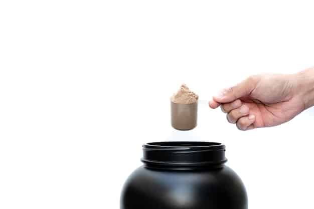 A close-up image of a person's hand scooping pre-workout powder from a container. The focus should be on the texture and color of the powder, highlighting the active ingredients and the preparation process of The Best Pre-Workout Supplements of 2025: Reviews and Comparisons.