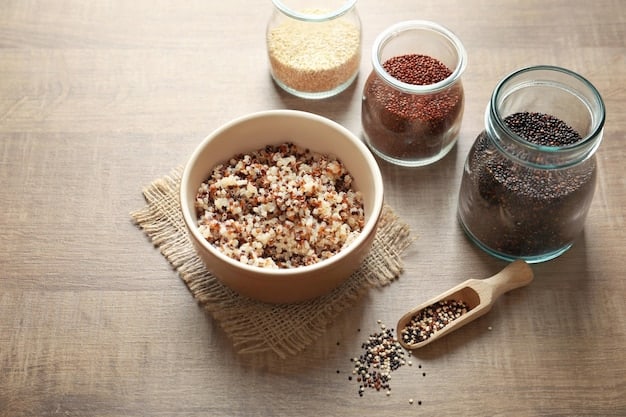 Close-up of different types of whole grains, such as brown rice, quinoa, and oats, displayed in separate bowls on a wooden table. Next to the bowls are slices of whole wheat bread.