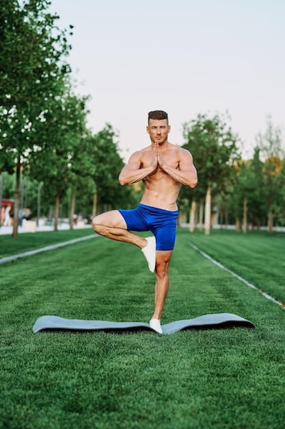 A man practicing yoga in a park, demonstrating a complex pose with strength and control. The background includes natural scenery, reflecting a connection with nature and highlighting how the benefits of yoga for men can be enjoyed in various environments.