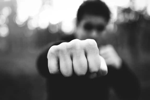 A black and white image of a clenched fist against a blurred background. The image symbolizes anger and frustration, pointing to Undetstanding Male Depression: 7 Often-Missed Symptoms.