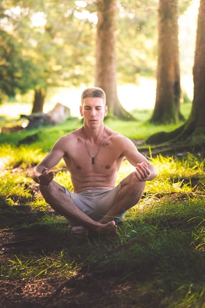 A serene image of a man practicing yoga in a natural setting, demonstrating the calming and grounding effects of mindfulness and physical activity in managing anxiety.