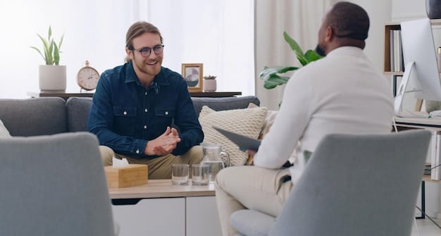 A professional therapist listening and engaging empathetically with a male client in a well-lit office setting.