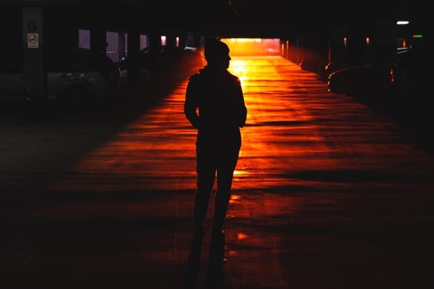 A silhouette of a man standing alone in a dark room, with faint city lights visible through a window. The image conveys a sense of loneliness, isolation, and the internal battles faced when Understanding PTSD in Men: Symptoms, Treatment, and Recovery.