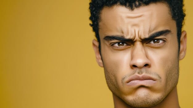 A close-up of a man's face showing a mix of anger and frustration. His brow is furrowed, and his jaw is clenched. The background is blurred, emphasizing the intensity of his emotions. This image illustrates the irritability and anger often associated with depression in men, as mentioned in 'Recognizing and Addressing the Signs of Depression in Men: A Comprehensive Guide'.