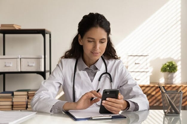 A person using a budgeting app on their smartphone to plan their healthcare spending for the upcoming year. The app displays categories for prescriptions, doctor visits, and sexual health products, with projected costs and contribution limits clearly visible.