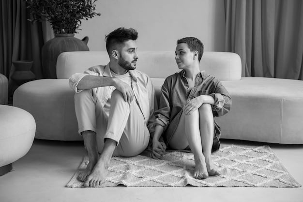 A couple sitting close together on a couch, facing each other with relaxed expressions. One is gently touching the other's arm, indicating empathy and attentive listening while they talk about How to Improve Your Sexual Communication with Your Partner: Expert Tips.